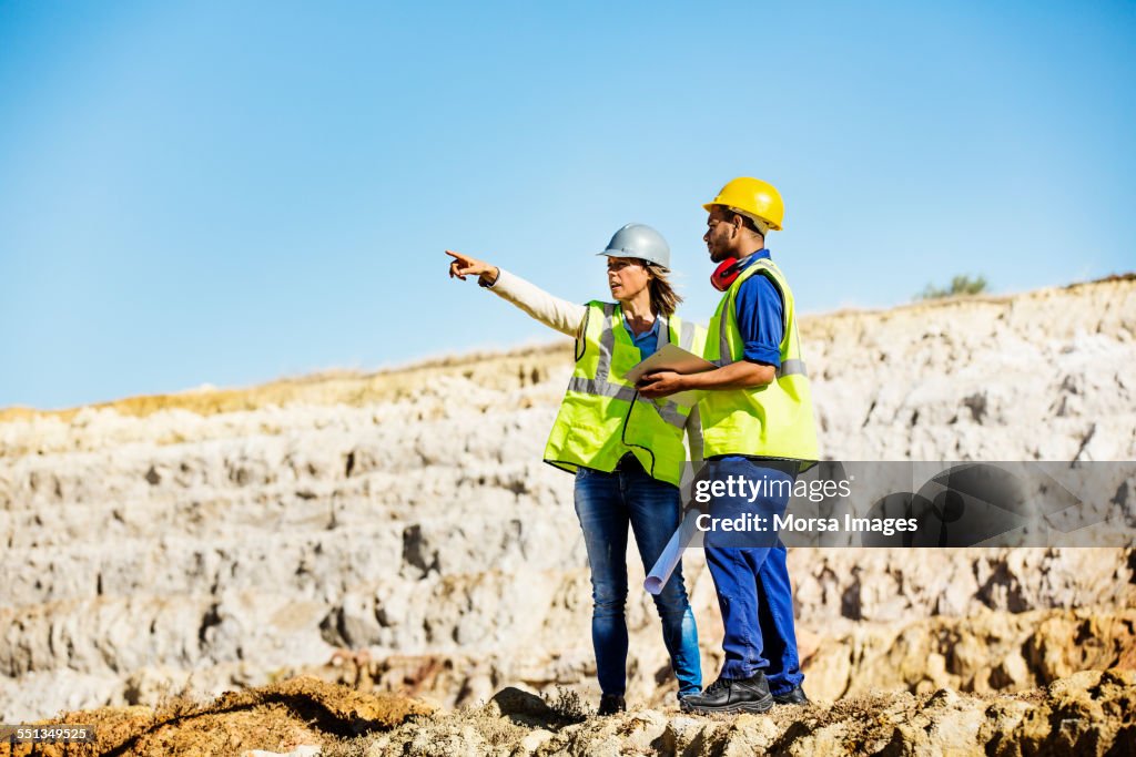 Architect explaining plan to quarry worker at site