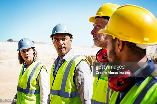 construction team discussing at quarry - ear defenders stock pictures, royalty-free photos & images