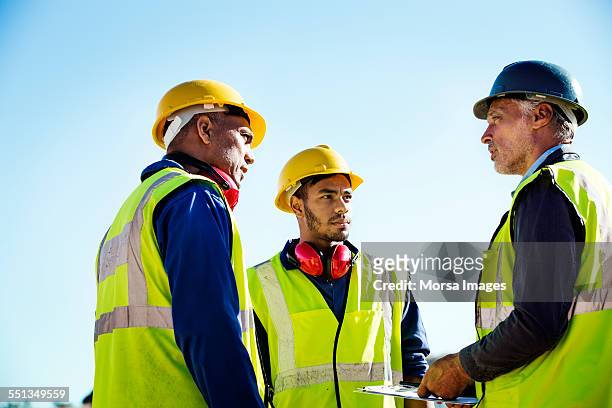 architect discussing with quarry workers - oorbeschermer stockfoto's en -beelden