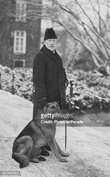 Kaiser Wilhelm II in the snow covered gardens of his exiled home with his dog, Holland, circa November 1918.