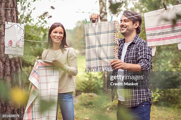 happy couple drying laundry in yard - laundry stock pictures, royalty-free photos & images