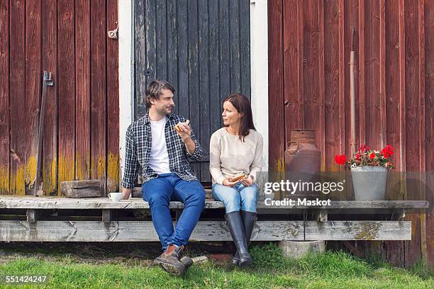 couple having breakfast while sitting outside barn at farm - farm couple fotografías e imágenes de stock