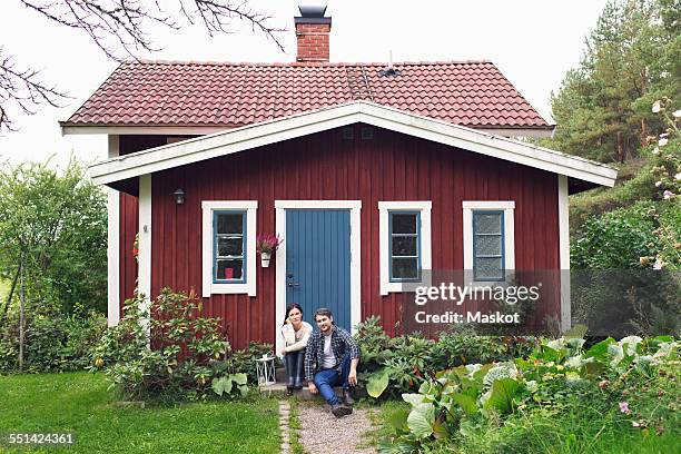 mid adult couple sitting outside farmhouse - summer cottage stock pictures, royalty-free photos & images