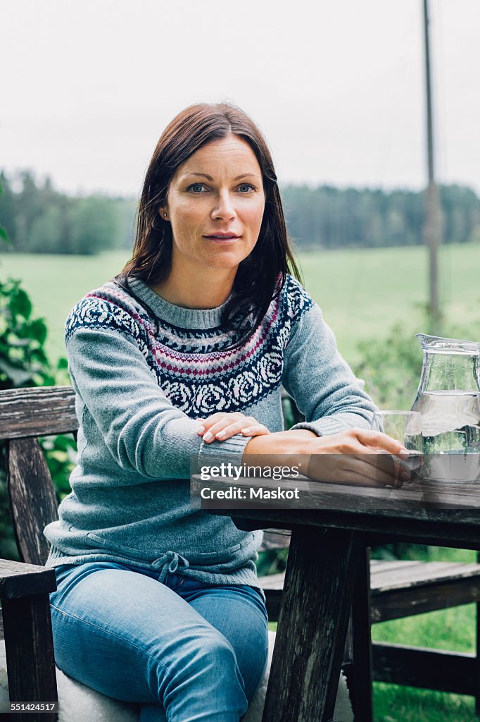 Portrait of confident woman sitting at table in organic farm