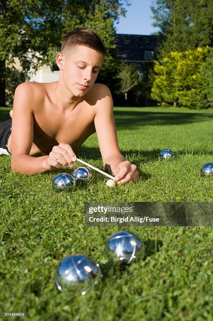 Teenage Boy Measuring Distance in Game of Boules