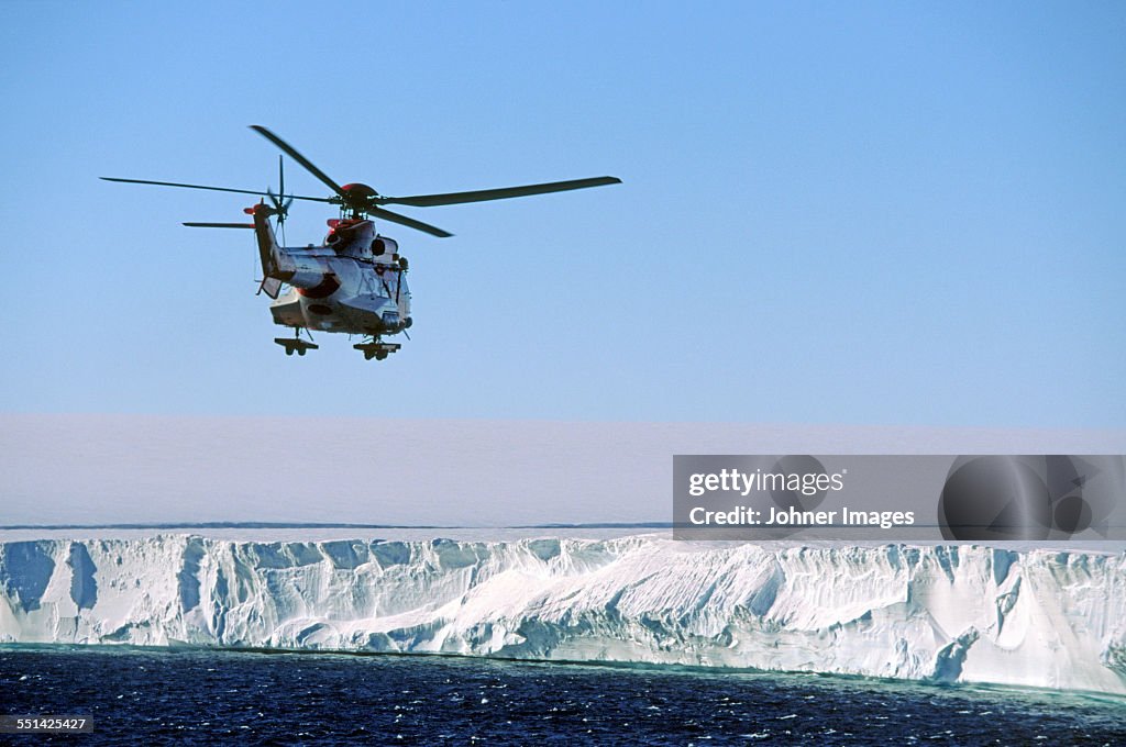 Helicopter over iceberg and sea