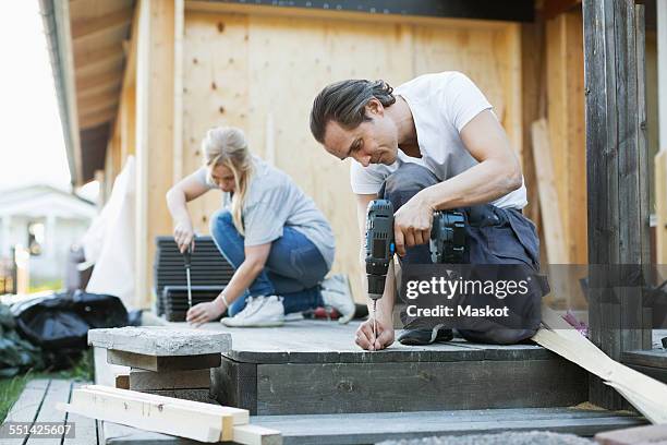 couple working outside house during home improvement - hemrenovering bildbanksfoton och bilder