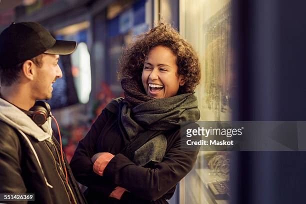happy multi-ethnic couple outside store at dusk - young couple shopping stock pictures, royalty-free photos & images