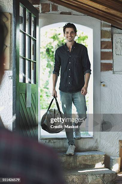 full length of happy man welcomed by friends - entering stock pictures, royalty-free photos & images