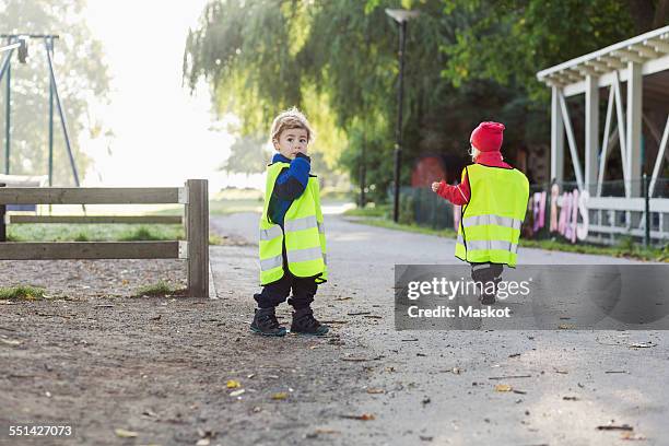 children in protective jackets walking on footpath - reflective clothing stock pictures, royalty-free photos & images