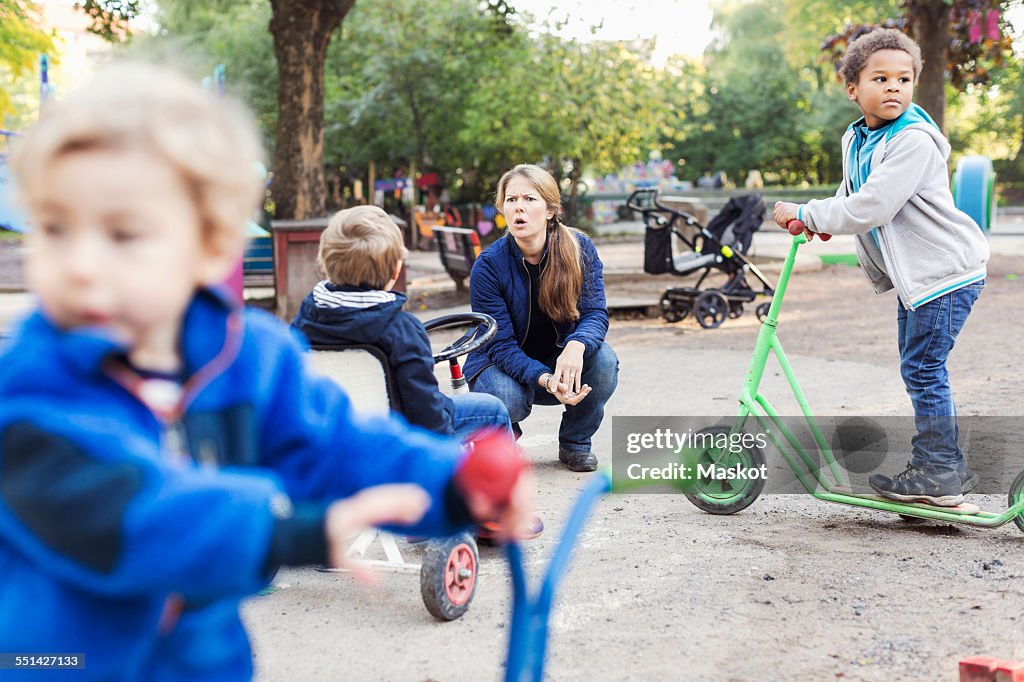 Angry teacher with children playing on playground