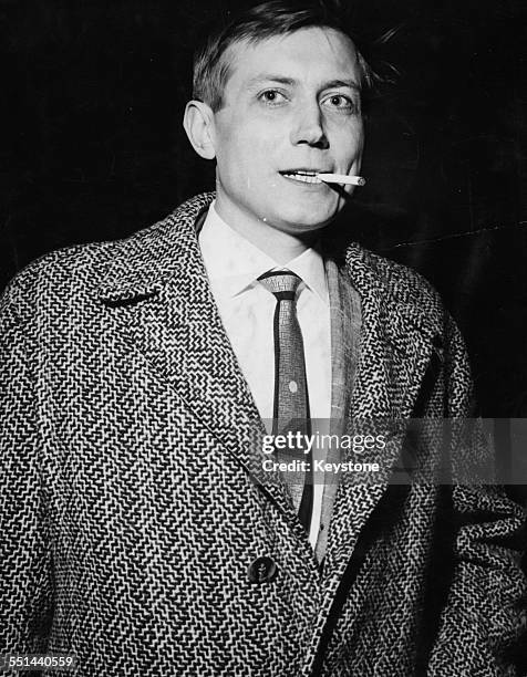 Russian poet Yevgeny Yevtushenko smoking a cigarette as he arrives in Britain at London Airport, April 28th 1962.