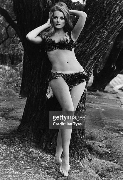 Portrait of actress Celeste Yarnall wearing a two piece, animal print bathing suit, posing in front of a tree at Regent's Park, London, August 16th...