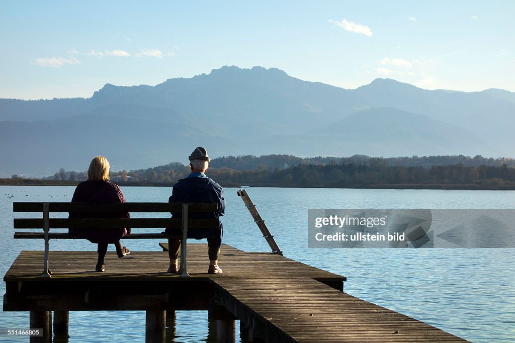 Man and woman sitting on a wooden bench seat