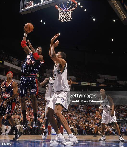 Kevin Willis of the Houston Rockets moves for the basket as he is guarded by Loren Woods of the Minnesota Timberwolves during the game at the Target...