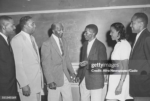 Group of men and one woman meeting and greeting on a stage, Baltimore, Maryland, 1941.