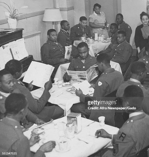 Full mess of African-American soldiers in uniform eating around a table, the United Services Organization, February 20, 1943.