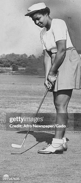 Marilyn Reynolds, a female African-American golfer, taking a put on a golf green at the Wake-Robin golf club, an African-American golf club in...