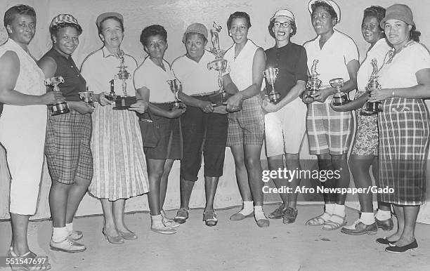 Large group of women golfers holding trophies, the tournament winners at the Wake Robin golf club, an African-American womens golf club in Washington...