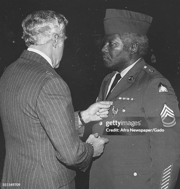 Mature African-American soldier in uniform, being presented with a medal, 1979.