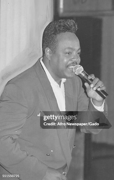 Peabo Bryson, an African-American R&B and soul singer-songwriter on stage with a microphone, 1975.