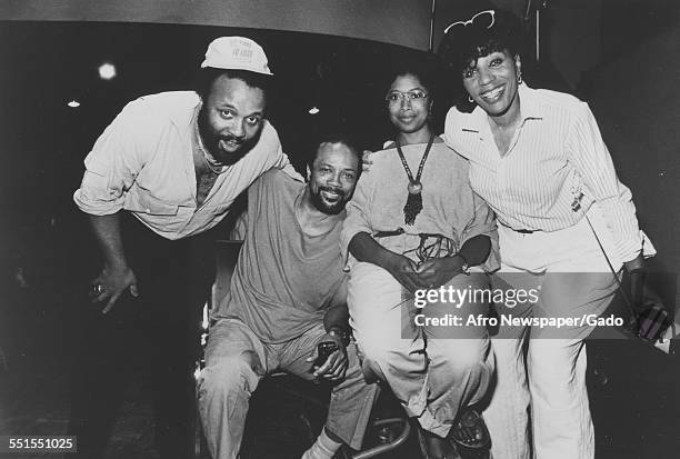 The gospel singer Andrae Crouch with three other people posing for a photograph, 2011.