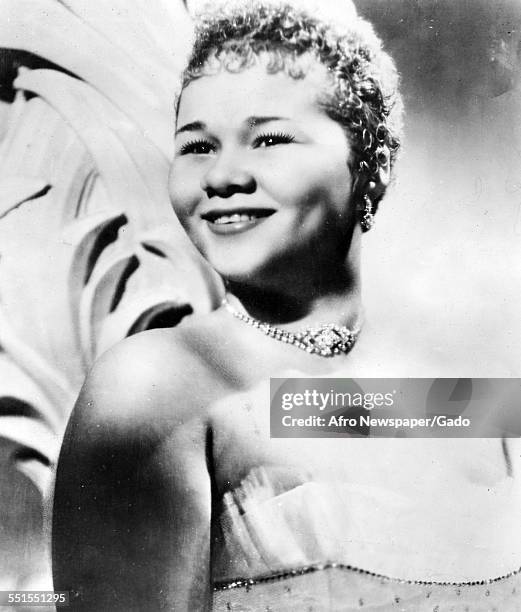 The singer songwriter Etta James, on stage, smiling, 1960.