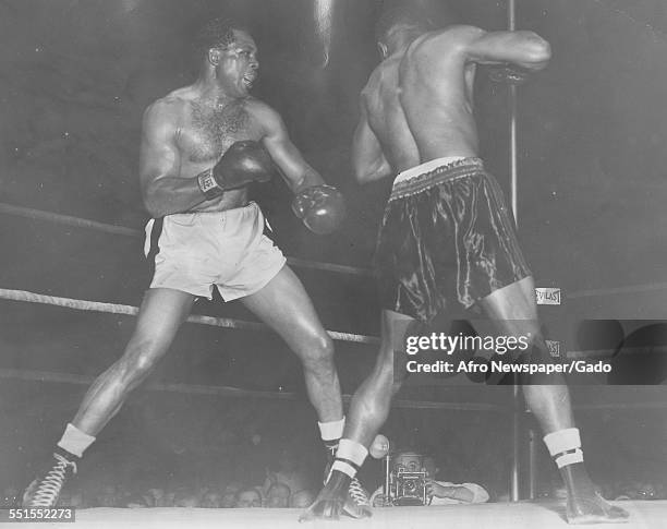 Archie Moore, an American professional boxer and the Light Heavyweight World Champion, defeating Clarence Henry in a match, June 28, 1952.