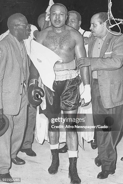 Archie Moore, African-American professional boxer and the Light Heavyweight World Champion, being escorted from the ring in the match with Pete...