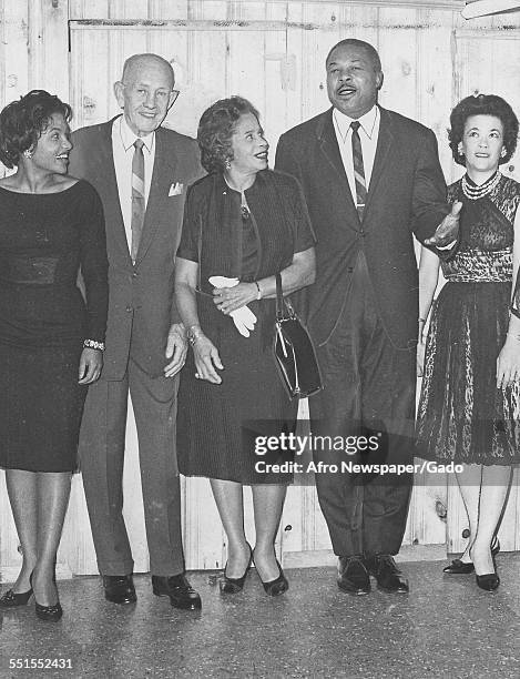 Archie Moore, African-American professional boxer and the Light Heavyweight World Champion, being welcomed back to Baltimore by boxing associates,...