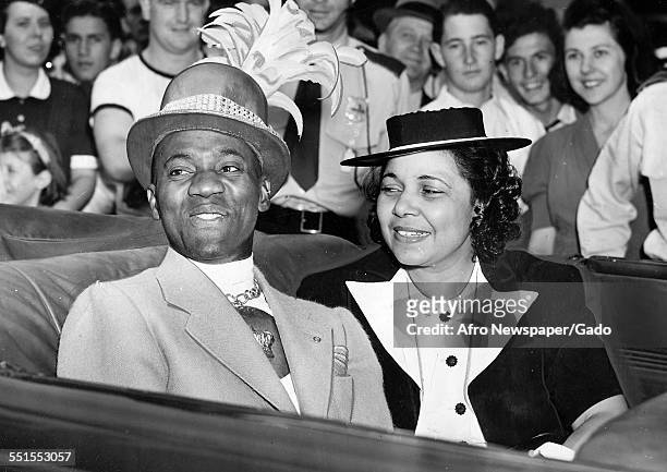 Mrs and Mrs Robinson in an open topped car among a crowd of fans on Bill Robinson day named in his honour at the New York Worlds Fair, New York City,...