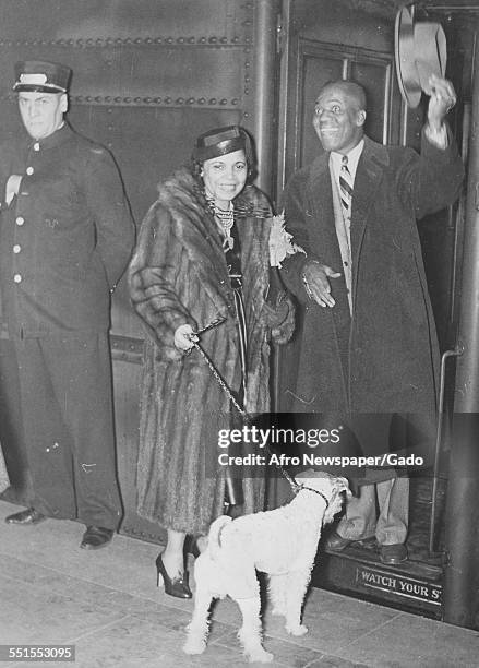 Bill Robinson, Bojangles his wife and a dog on a lead at the entrance to a club in New York, before leaving for California and Hollywood to make a...