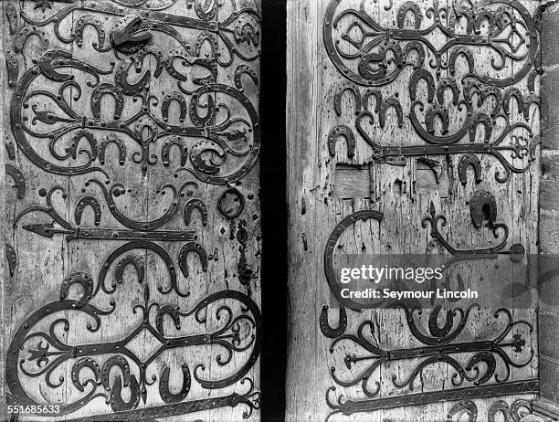 Horseshoes decorate the old wooden door to the Église Saint-Martin, the church of St Martin in Chablis, Burgundy, France, circa 1925.