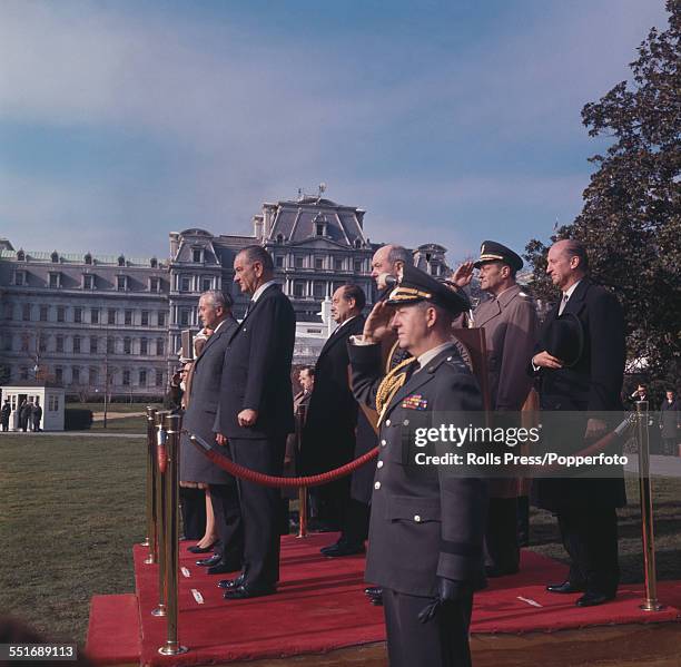 Prime Minister of the United Kingdom, Harold Wilson stands with President of the United States, Lyndon B Johnson during the playing of national...