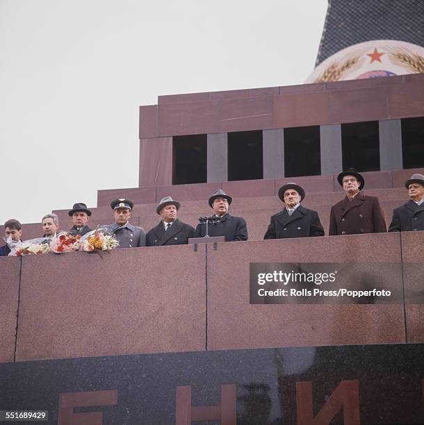 View of Communist Party members of the Soviet Politburo and cosmonauts lining up on the platform above Lenin's tomb in Red Square, Moscow to welcome...