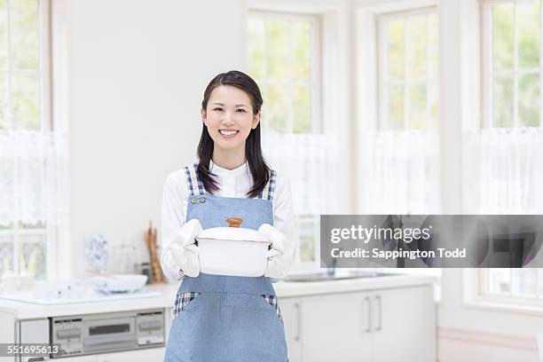 woman holding cooking pot - persona di casa foto e immagini stock