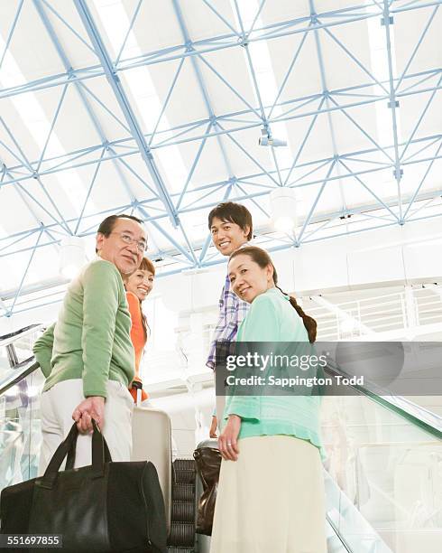 family with luggage on escalator - asian ceiling fotografías e imágenes de stock