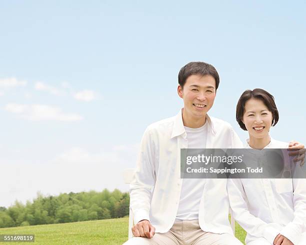 couple sitting on bench - pareja de mediana edad fotografías e imágenes de stock