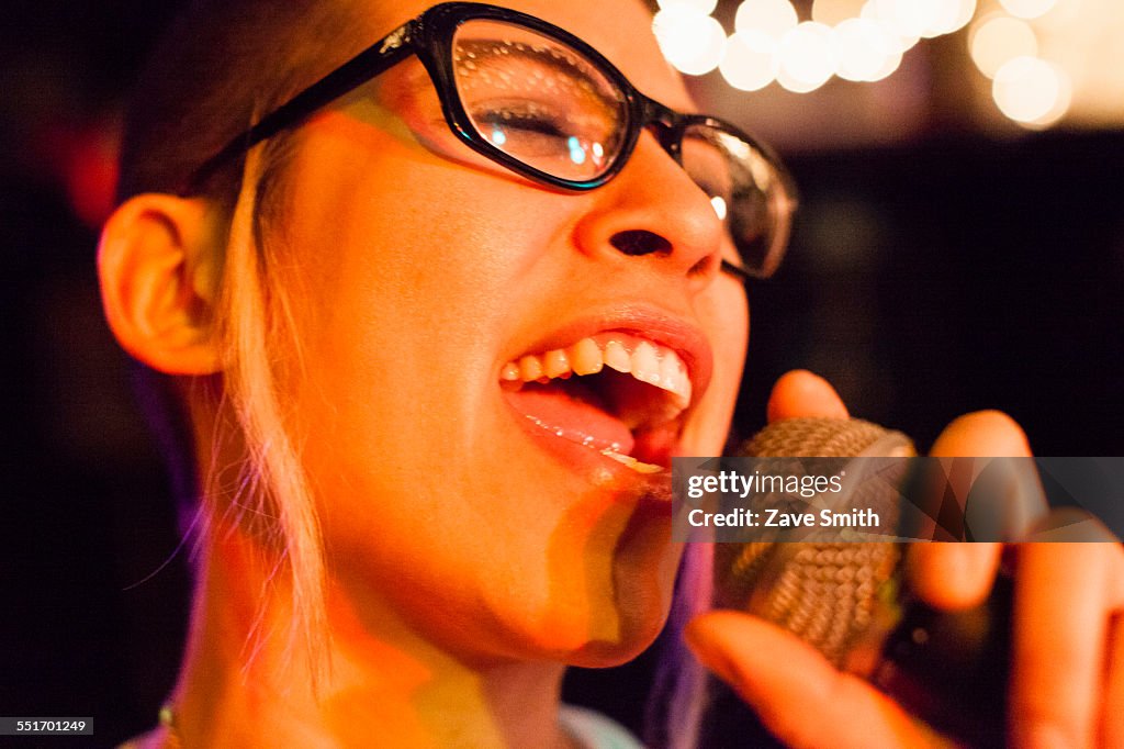 Punk girl singing into microphone, close-up