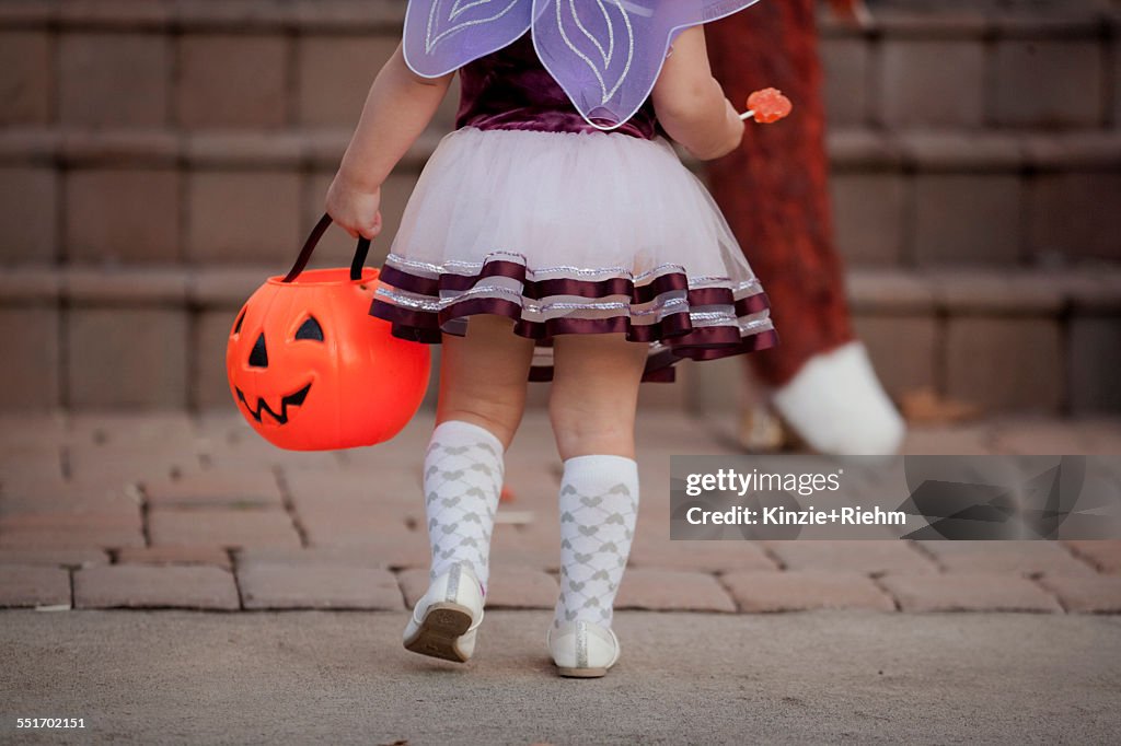 Toddler carrying Jack O Lantern bucket