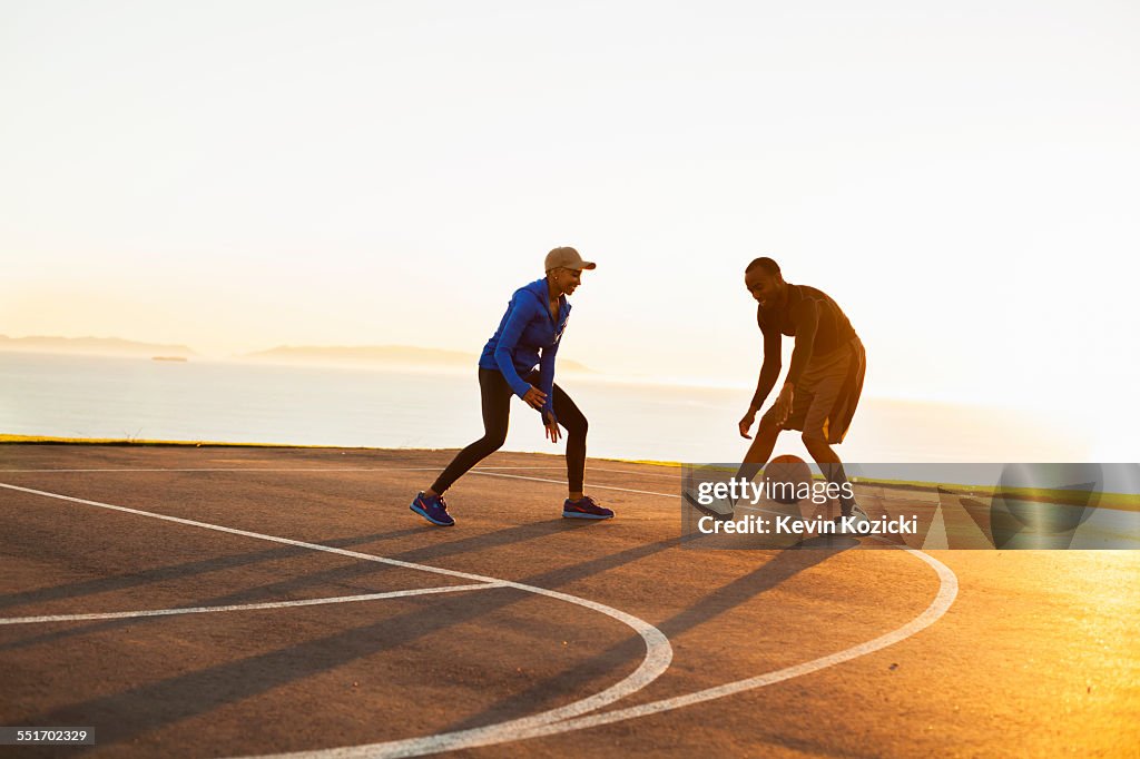 Two friends playing basketball, outdoors