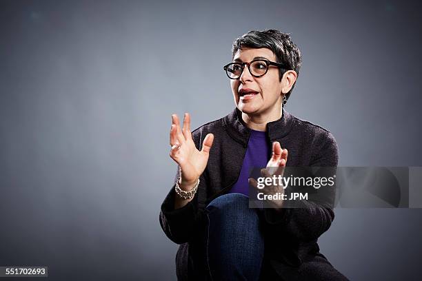 studio portrait of mature businesswoman explaining with open hands - explain foto e immagini stock