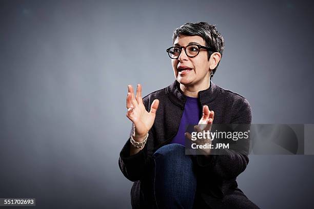 studio portrait of mature businesswoman explaining with open hands - explaining stock pictures, royalty-free photos & images