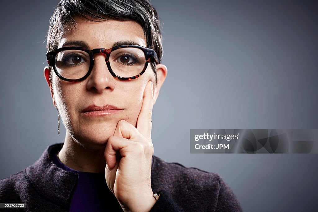 Studio portrait of mature businesswoman hand on cheek