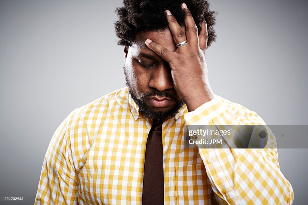 Studio portrait of mid adult businessman with hand on face