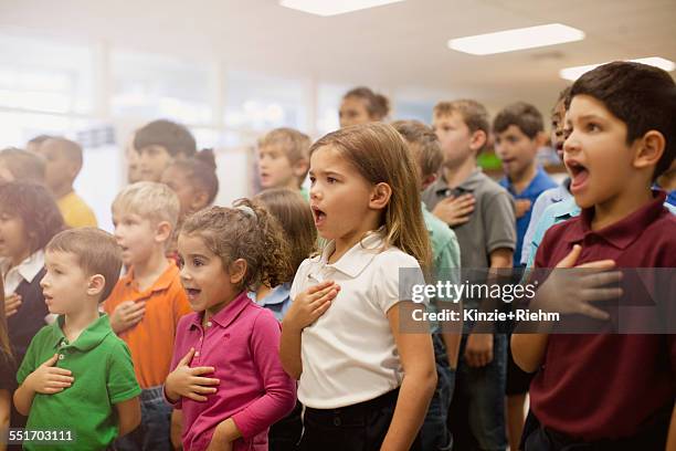 children reciting pledge of allegiance in school - pledge of allegiance fotografías e imágenes de stock