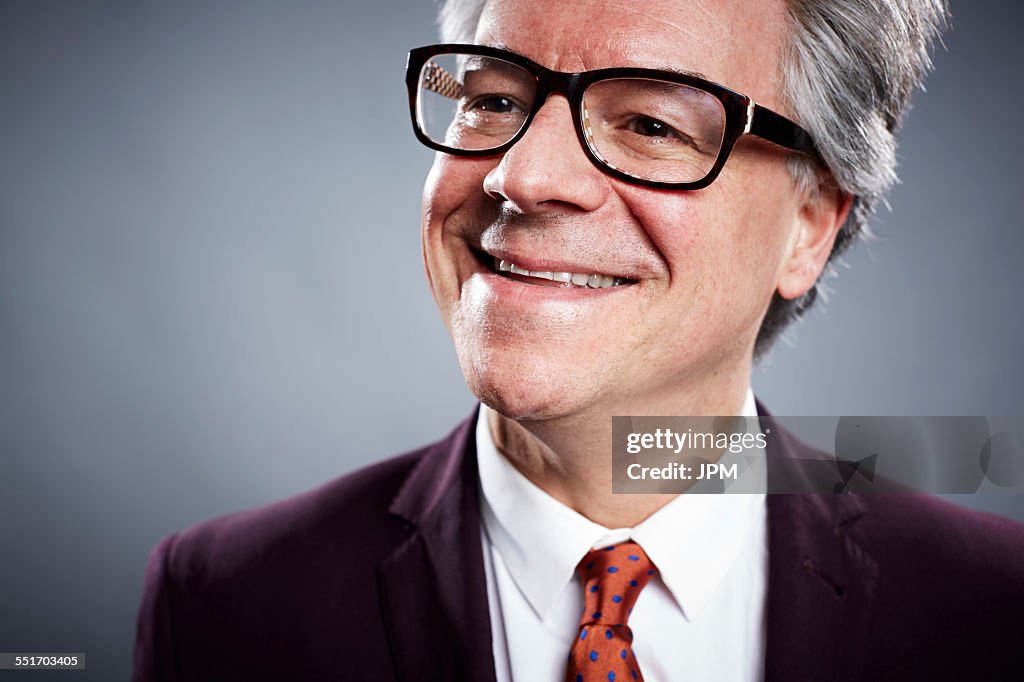 Close up studio portrait of smiling mature businessman