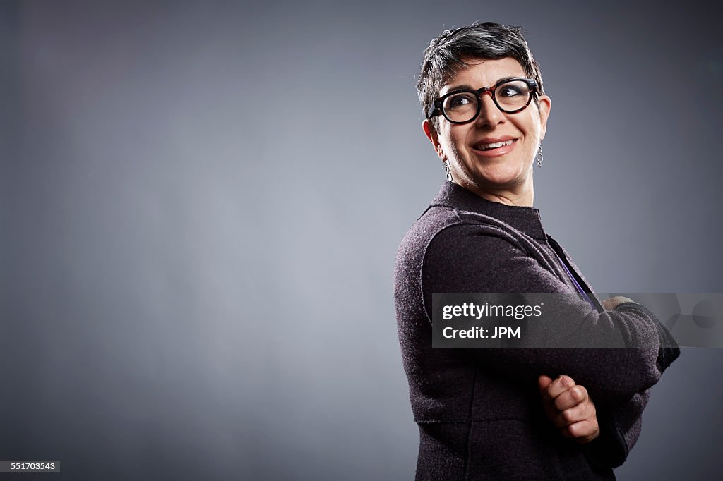 Studio portrait of mature businesswoman looking over her shoulder