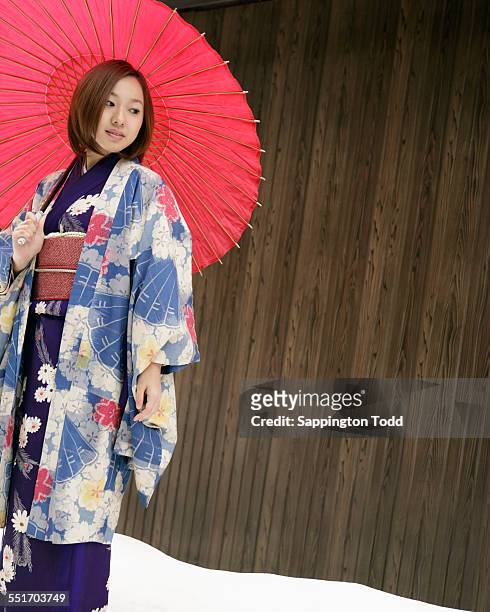 young woman in kimono with red umbrella - kimono winter stock pictures, royalty-free photos & images
