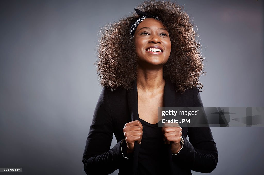 Studio portrait of young businesswoman with fists clenched